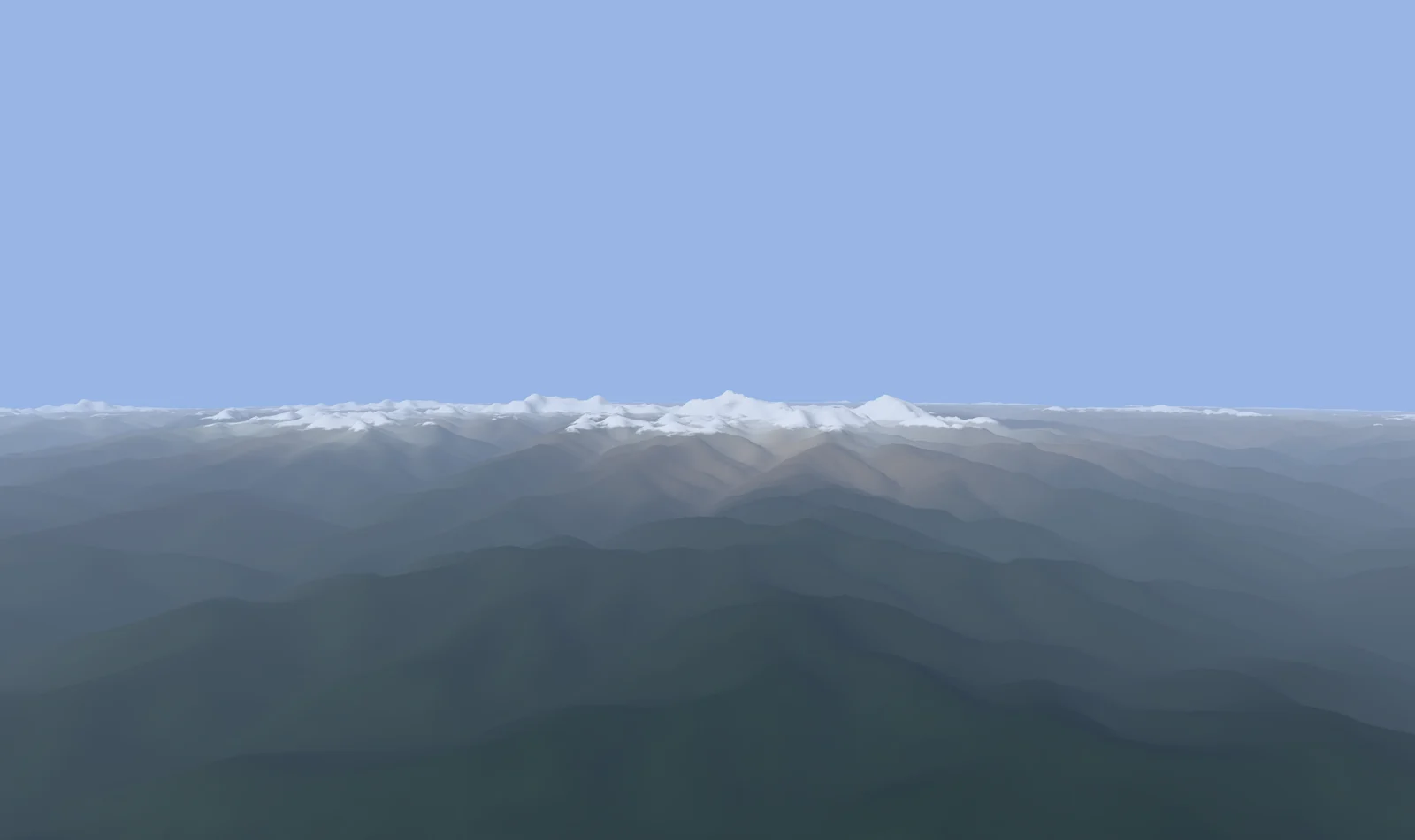 Forested foothills rising ridge after ridge toward a line of snow-covered peaks.